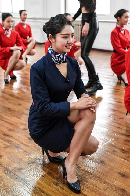 Students attend a stewardess skill training for the upcoming 2017 entrance examination for art majors in colleges in Luoyang, central China's Henan Province, January 4, 2017. The proper way to crouch down in the restrictive skirts of their uniforms is also taught to the soon-to-be cabin crew. (Photo by Li Bo/Xinhua/Barcroft Images)