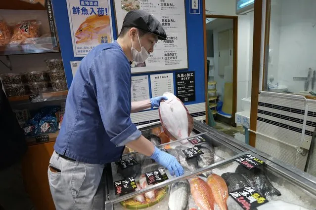 A staff member holds a flounder from Fukushima at Sakana Bacca, a seafood retailer, on October 31, 2023, in Tokyo. Fishing communities in Fukushima feared devastating damage to their businesses from the tsunami-wrecked nuclear power plant’s ongoing discharge of treated radioactive wastewater into the sea. Instead, they're seeing increased consumer support as people eat more fish, a movement in part helped by China’s ban on Japanese seafood. (Photo by Eugene Hoshiko/AP Photo)