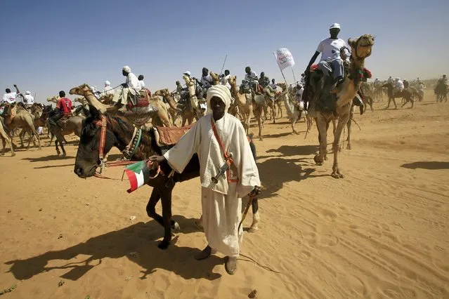 Supporters of the National Congress Party (NCP) and presidential candidate, Sudan's President Omar Hassan al-Bashir ride camels and horses to attend the last campaign rally for the states at Al Fashir in North Darfur, ahead of the 2015 elections, April 8, 2015. (Photo by Mohamed Nureldin Abdallah/Reuters)