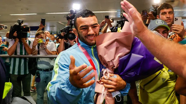 Ukraine's Olympic-medal-winning wrestlers, Zhan Beleniuk (left) and Parviz Nasibov (partially obscured on the right), arrive back from Tokyo in Boryspil airport on August 6, 2021. (Photo by Serhii Nuzhnenko/Radio Free Europe/Radio Liberty)