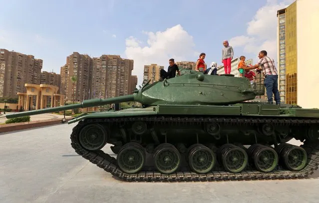 People sit on top of a military tank, displayed at the 6th of October War Panorama Museum, on the day of the 50th anniversary of Egypt's attack on Israeli forces during the 1973 Arab–Israeli War, in Cairo, Egypt on October 6, 2023. (Photo by Mohamed Abd El Ghany/Reuters)