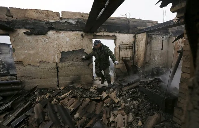 Local resident Sergei Shvedchikov, 61, enters his burnt house to collect scrap metal in the settlement of Shyra, damaged by recent wildfires, in Khakassia region, April 13, 2015. (Photo by Ilya Naymushin/Reuters)