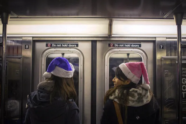 Women wear festive hats while traveling on the subway through Midtown, Manhattan on Christmas Eve in New York December 24, 2013. (Photo by Adrees Latif/Reuters)