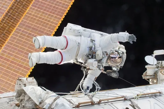 This NASA image released December 22, 2015 shows Expedition 46 Commander Scott Kelly on a December 21, 2015 spacewalk, in which Kelly and Flight Engineer Tim Kopra successfully moved the International Space Station's mobile transporter rail car ahead of Wednesday's docking of a Russian cargo supply spacecraft. After quickly completing their primary objective for the spacewalk, Kelly and Kopra tackled several additional “get-ahead” tasks. Kelly routed a second pair of cables in preparation for International Docking Adapter installment work to support US commercial crew vehicles. (Photo by AFP Photo/NASA)