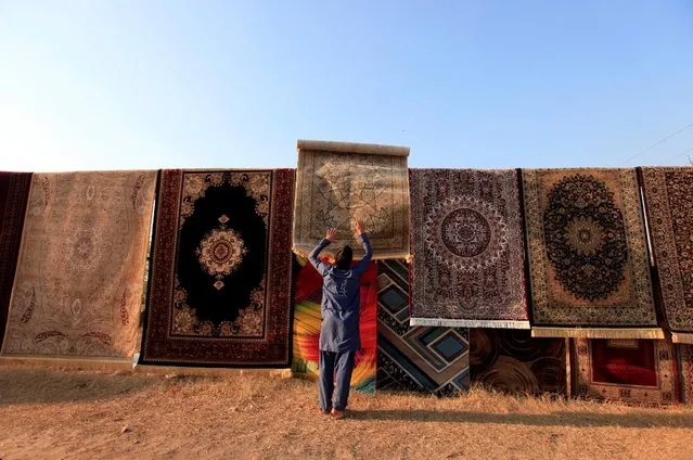 A man throws a carpet on a wire to put it on display and for sale along a roadside in Islamabad, Pakistan, January 12, 2017. (Photo by Faisal Mahmood/Reuters)