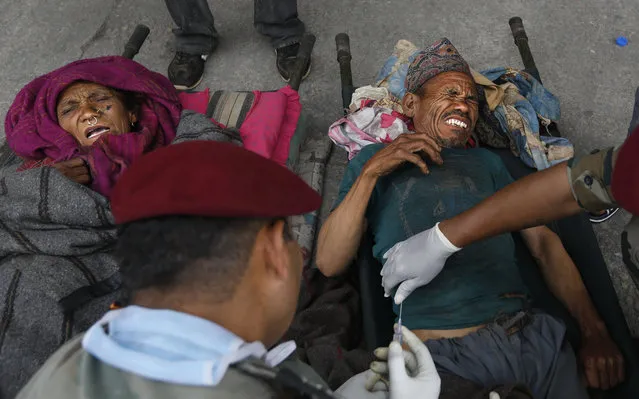 An Indian army doctor administers an injection to an injured man after he was evacuated from higher reaches of mountains by Nepalese army, in Kathmandu, Nepal, Wednesday, April 29, 2015. (Photo by Manish Swarup/AP Photo)