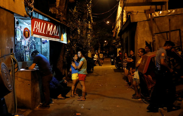 Residents gather along a street after a man was chased and killed on the second floor of a house during what police said was a drug related vigilante killing in Pasig, Metro Manila, Philippines February 1, 2017. (Photo by Erik De Castro/Reuters)