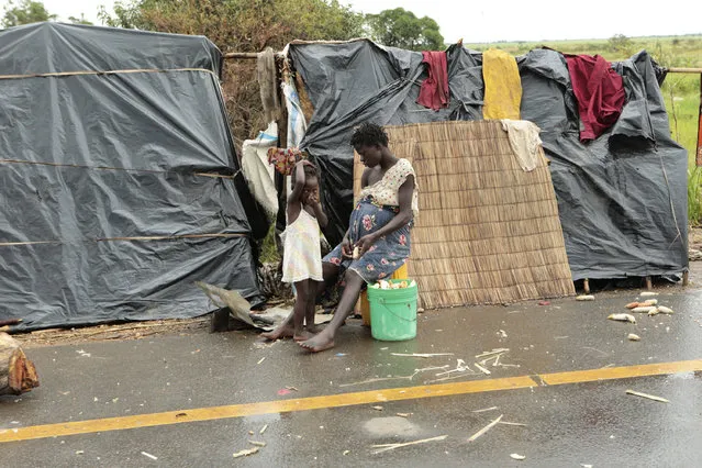 Survivors of Cyclone Idai in a makeshift shelter by the roadside near Nhamatanda about 50 kilometres from Beira, in Mozambique, Friday March, 22, 2019. As flood waters began to recede in parts of Mozambique on Friday, fears rose that the death toll could soar as bodies are revealed. (Photo by Tsvangirayi Mukwazhi/AP Photo)