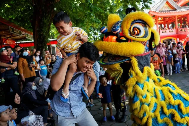 A child reacts as a performer performs in a Lion Dance at the Sam Poo Kong temple ahead of the Lunar New Year in Semarang, Central Java province, Indonesia, on February 8, 2024. (Photo by Willy Kurniawan/Reuters)