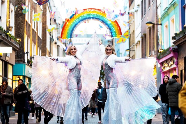 Stilt walkers Sophie Wragg, left, and Charlotte Turner at the Carnaby Street Christmas installation in London, United Kingdom on November 4, 2021, featuring 600 neon butterflies in partnership with the charity Choose Love. (Photo by David Parry/PA Wire Press Association)