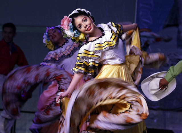 A dancer performs during Cinco de Mayo celebrations in Portland, Ore., Tuesday, May 5, 2015. Ballet Folklorico Mexico En La Piel performed at the annual Portland event accompanied by the band Mariachi Guadalajara from Jalisco, Mexico. (Photo by Don Ryan/AP Photo)