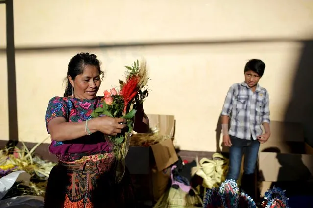 A woman and her son prepare roses for the “Jesus Nazareno de la Merced” procession as part of Holy Week in downtown Guatemala City, Guatemala, March 22, 2016. (Photo by Saul Martinez/Reuters)