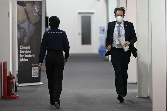 Luxembourg negotiator Andrew Ferrone runs inside the venue of the COP26 U.N. Climate Summit in Glasgow, Scotland, Friday, November 12, 2021. Negotiators from almost 200 nations were making a fresh push Friday to reach agreements on a series of key issues that would allow them to call this year's U.N. climate talks a success. (Photo by Alastair Grant/AP Photo)