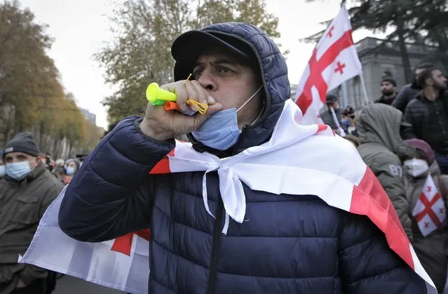 A demonstrators attends a rally in support of former President Mikheil Saakashvili in Tbilisi, Georgia, Friday, November 19, 2021. Several thousand people have rallied in the Georgian capital of Tbilisi, demanding that authorities in the ex-Soviet nation transfer the jailed ex-president to a civilian hospital amid reports that his health is deteriorating after weeks of being on a hunger strike. (Photo by Shakh Aivazov/AP Photo)