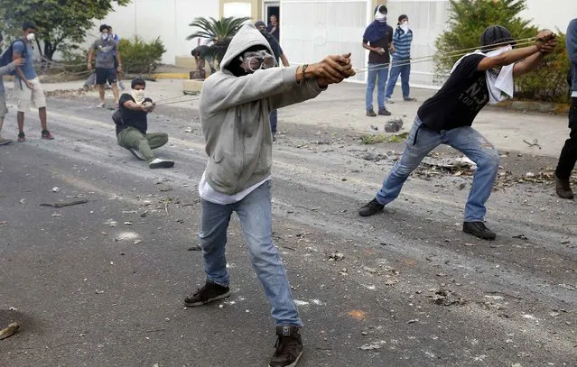 Demonstrators use slingshots against National Guards during a protest against Venezuelan President Nicolas Maduro's government in San Cristobal, about 410 miles (660 km) southwest of Caracas, February 27, 2014. U.N. Secretary-General Ban Ki-moon and Pope Francis called on Wednesday for an end to violence in Venezuela that has killed at least 13 people and urged politicians to take the lead in calming the nation's worst unrest in a decade. (Photo by Carlos Garcia Rawlins/Reuters)