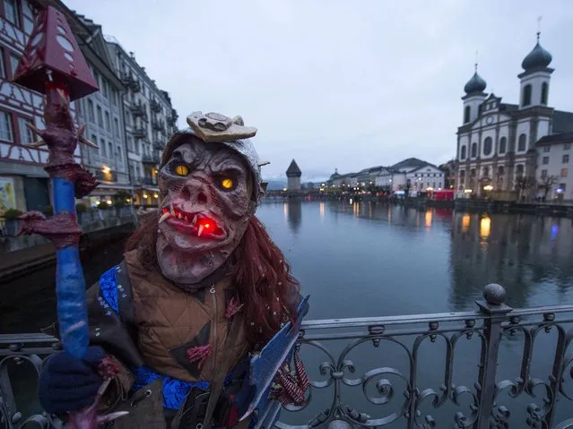 A carnival participant in costume poses in the historic center of Lucerne. (Photo by Sigi Tischler/Keystone)