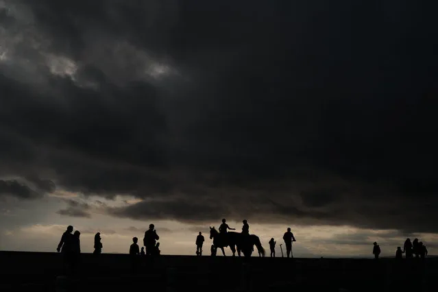 People walk in front of Mediterranean sea on the French riviera city of Nice, on November 13, 2021. (Photo by Valery Hache/AFP Photo)