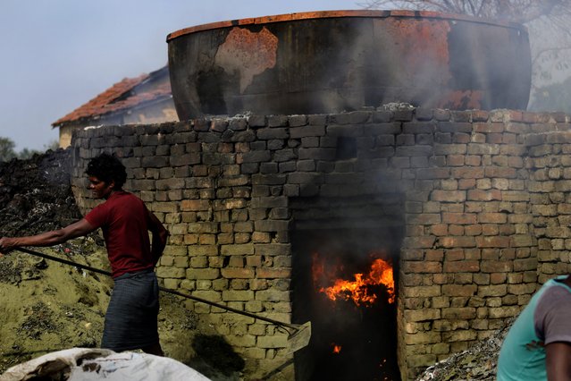 Indian laborers boil leather waste to prepare organic fertilizer near a tannery workshop in Kolkata, eastern India, 10 October 2013. (Photo by Piyal Adhikary/EPA)