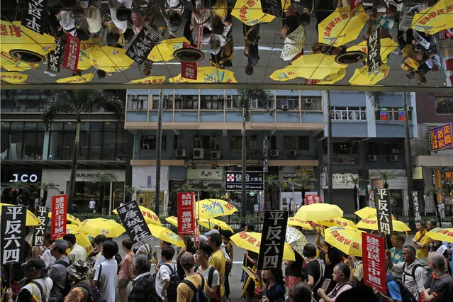 Pro-democracy protesters carry a banner with Chinese reads “Vindicate June 4th” during a demonstration in Hong Kong, Sunday, May 26, 2019. A vigil will be held on June 4 at the Victoria Park to mark the 30th anniversary of the military crackdown on the pro-democracy movement at Beijing's Tiananmen Square on June 4, 1989. (Photo by Kin Cheung/AP Photo)