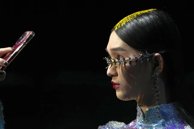 A model takes a selfie during rehearsal for the Moe Ho collection by designer Mengmeng He, during China Fashion Week in Beijing, March 29, 202. (Photo by Ng Han Guan/AP Photo)
