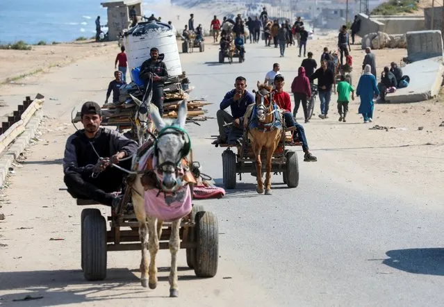 People ride animal-drawn carts as Palestinians, who were displaced by Israel's military offensive on south Gaza, make their way attempting to return to their homes in north Gaza through an Israeli checkpoint, as seen from central Gaza Strip, on April 15, 2024. (Photo by Ramadan Abed/Reuters)