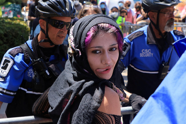 A pro-Palestinian demonstrator reacts as she is escorted by security personnel after scuffling with an observer, as protesters in support of Palestinians in Gaza and pro-Israel counter-protesters gather at the encampment on the campus of the University of California Los Angeles (UCLA), amid the ongoing conflict between Israel and the Palestinian Islamist group Hamas, in Los Angeles, California, U.S. April 29, 2024. (Photo by David Swanson/Reuters)