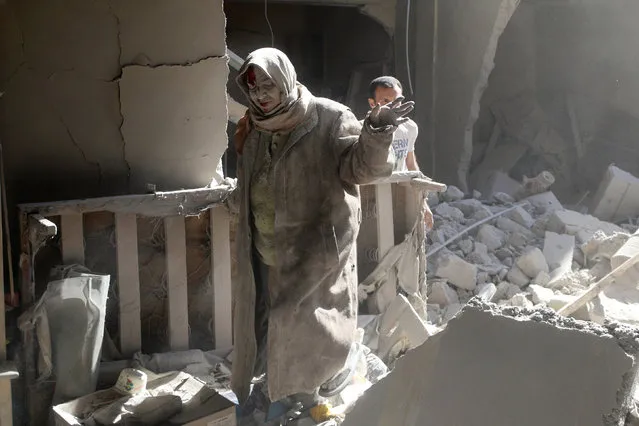 An injured woman reacts at a site hit by airstrikes in the rebel held area of Old Aleppo, Syria, April 28, 2016. (Photo by Abdalrhman Ismail/Reuters)