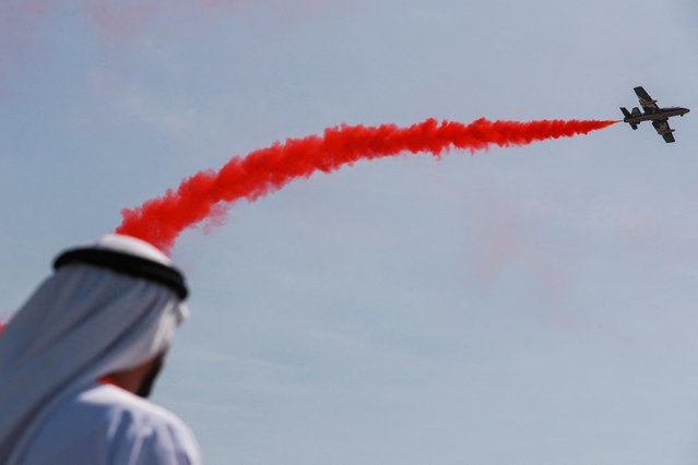 A person watches an airshow at NAVDEX, an annual event that happens alonside the International Defence Exhibition and Conference (IDEX) in Abu Dhabi, United Arab Emirates on February 20, 2023. (Photo by Amr Alfiky/Reuters)