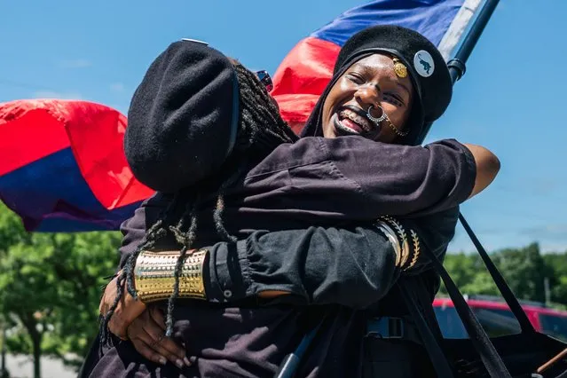 Women from the Huey P Newton Gun Club (HPNGC) organization embrace in the Greenwood district of Tulsa during commemorations of the 100th anniversary of the Tulsa Race Massacre on May 29, 2021 in Tulsa, Oklahoma. May 31st of this year marks the centennial of when a white mob started looting, burning and murdering in Tulsa’s Greenwood neighborhood, then known as Black Wall Street, killing up to 300 people and displacing thousands more. Organizations and communities around Tulsa are preparing to honor and commemorate survivors and community residents. (Photo by Brandon Bell/Getty Images)