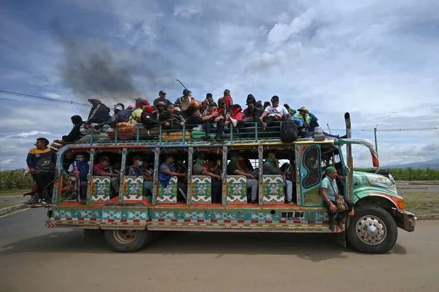 Colombian indigenous people are transported on a “chiva” (local bus) during a new protest against the government held in the framework of a national strike triggered by a now abandoned tax reform, on a Panamerican way in Cali, Colombia, on May 11, 2021. At least 42 people, including a uniformed officer, have died in Colombia as part of the anti-government protests that started on April 28 and escalated into a severe crisis due to internationally condemned repression. (Photo by Luis Robayo/AFP Photo)