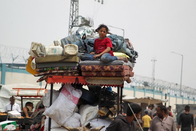 A girl looks on, while Palestinians travel on foot along with their belongings, as they flee Rafah due to an Israeli military operation, in Rafah, in the southern Gaza Strip on May 28, 2024. (Photo by Hatem Khaled/Reuters)