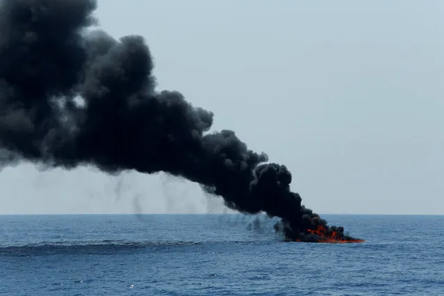 A rubber dinghy is burnt and sunk after the migrants on board were rescued by the Malta-based NGO Migrant Offshore Aid Station (MOAS) in the central Mediterranean north of Sabratha on the Libyan coast, April 5, 2017. (Photo by Darrin Zammit Lupi/Reuters)