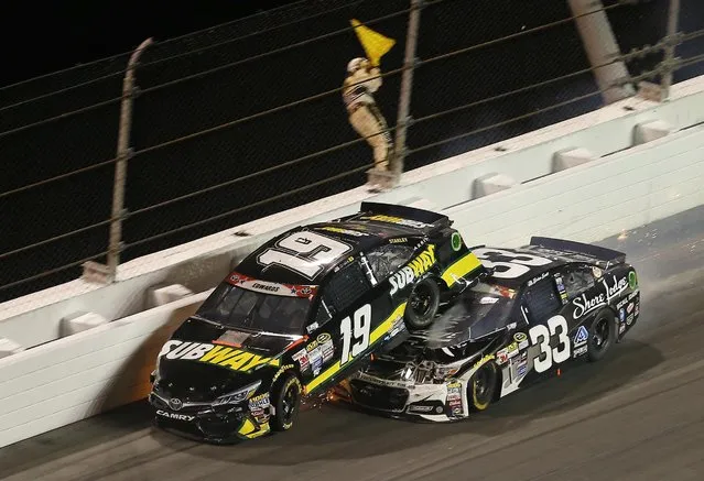 Brian Scott (33) goes under Carl Edwards (19) as they wreck in turn 2 during a NASCAR Sprint Cup series auto race at Daytona International Speedway, Monday, July 6, 2015, in Daytona Beach, Fla. (Photo by John Moore/AP Photo)