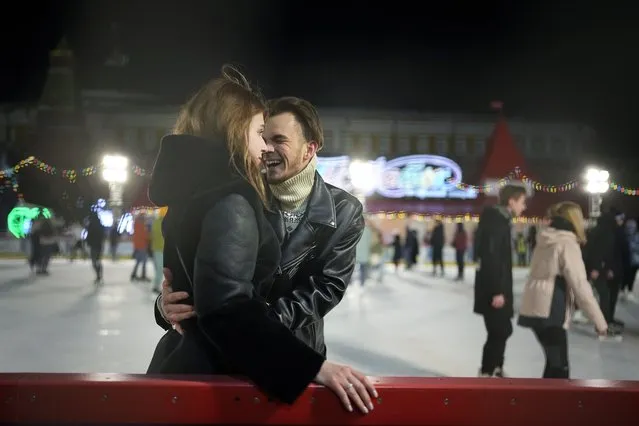 A couple enjoy the ice rink in Red Square at the Moscow GUM State Department store with the Kremlin Wall in the background in Moscow, Russia, late Monday, February 14, 2022. (Photo by Alexander Zemlianichenko/AP Photo)