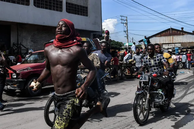 Demonstrators march on the street near parliament as they protest against ruling government in Port-au-Prince, on September 23, 2019. (Photo by Chandan Khanna/AFP Photo)