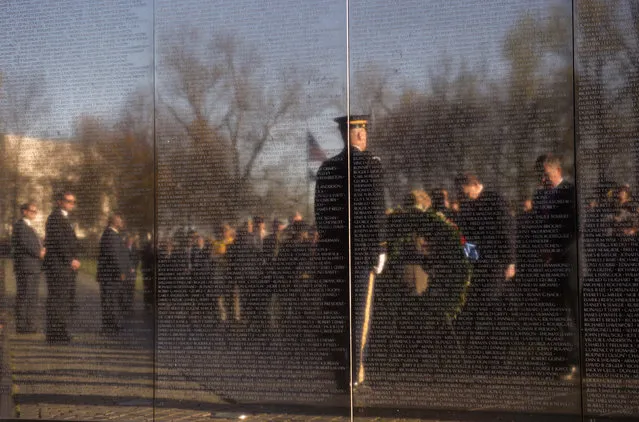 Defense Secretary Ash Carter, right and Veterans Affairs Secretary Robert McDonald are reflected in the Vietnam Memorial Wall as they bow there heads in silence to during a wreath laying ceremony to mark the 50th anniversary of the Vietnam War in Washington, Tuesday, March 29, 2016. (Photo by Molly Riley/AP Photo)
