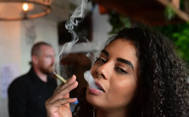 Kush Doleo smokes a joint at the Lowell Cafe in West Hollywood, California, on September 30, 2019, a day before its official opening. America's first cannabis restaurant has opened in West Hollywood, offering diners an array of weed products and hoping to rival Amsterdam's famed coffee shops. Called Lowell Farms: A Cannabis Cafe, the much-hyped 240-seat establishment is open to people 21 and over, who can order from a cannabis menu just like they would a wine bottle. (Photo by Frederic J. Brown/AFP Photo)