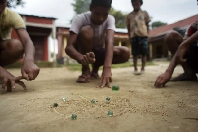 In this Tuesday, July 7, 2015 photo, children play marbles in the village of Mayong, east of Gauhati, India. (Photo by Anupam Nath/AP Photo)