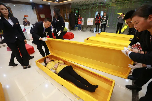 A woman lies in a coffin during an opening day of a funeral parlour in Chongqing, China on April 28, 2017. (Photo by Reuters/Stringer)