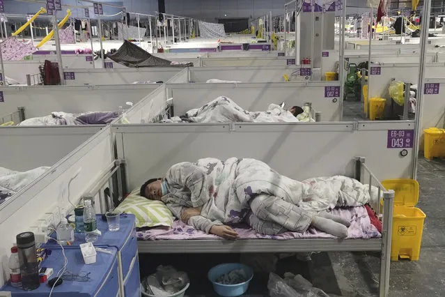 Residents rests at a temporary hospital converted from the National Exhibition and Convention Center to quarantine COVID-positive people in Shanghai, China on April 18, 2022. Interviews with family members of people testing positive for COVID-19, a phone call with a government health official and an independent tally raise questions about how Shanghai calculates virus cases and deaths, almost certainly resulting in a marked undercount. (Photo by Chinatopix via AP Photo)