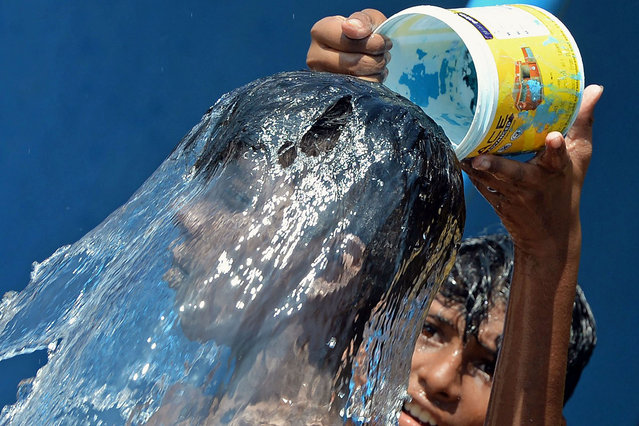 Boys cool off on a hot summer day in Chennai on April 7, 2022. (Photo by Arun Sankar/AFP Photo)