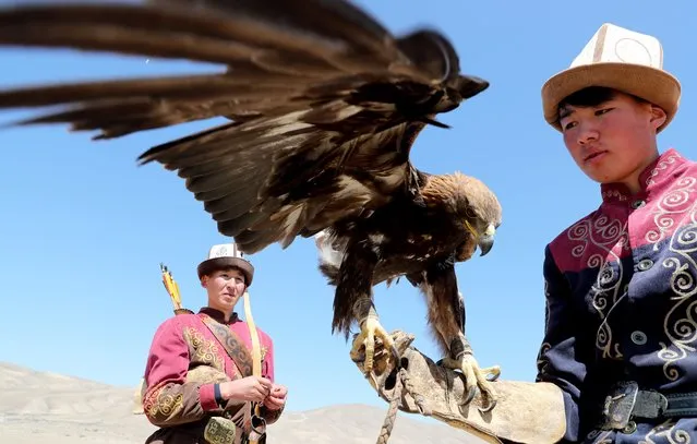 A Kyrgyz berkutchi (eagle hunters) holds his golden eagle, during the national hunting festival Salburun in Bokonbaevo near Lake Issyk-Kul, 250 km from the country's capital Bishkek, Kyrgyzstan, 16 April 2022. Salbuurun is a Kyrgyz hunting game with birds of prey and dogs. In Kyrgyzstan, hunting with golden eagles is still a popular way to feed a family. (Photo by Igor Kovalenko/EPA/EFE)
