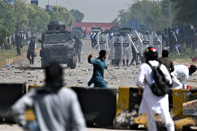 Pakistan Tehreek-e-Insaf (PTI) party activists and supporters (foreground) of former Pakistan's Prime Minister Imran Khan clash with police during a protest against the arrest of their leader, in Islamabad on May 10, 2023. Former Pakistan prime minister Imran Khan was on May 10 detained for two weeks on graft charges, local media reported, as a second day of violent nationwide protests over his arrest erupted. (Photo by Aamir Qureshi/AFP Photo)