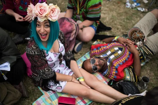 Music fans rest on the grass in front of the Pyramid Stage at the Glastonbury Festival of Music and Performing Arts on Worthy Farm near the village of Pilton in Somerset, south- west England on June 23, 2017. (Photo by Oli Scarff/AFP Photo)
