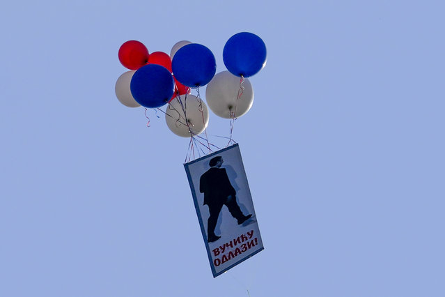 Balloons with a photo of Serbian President Aleksandar vucic that reads: “Vucic go away!” fly during a protest against violence in Belgrade, Serbia, Saturday, June 3, 2023. Tens of thousands of people rallied in Serbia's capital on Saturday in protest of the government's handling of a crisis after two mass shootings in the Balkan country. (Photo by Darko Vojinovic/AP Photo)