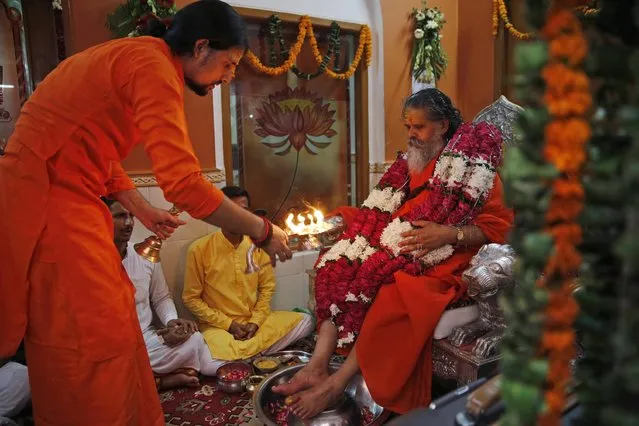 A Hindu devotee prays to his Guru on the occasion of Guru Purnima, or full moon day dedicated to the Guru, in Allahabad, India, Friday, July 31, 2015. (Photo by Rajesh Kumar Singh/AP Photo)