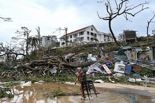 A woman collects chairs amid debris and fallen trees after Super Typhoon Yagi hit Ha Long, in Quang Ninh province, on September 8, 2024. Super Typhoon Yagi uproots thousands of trees, sweeps ships and boats out to sea and rips roofs off houses in northern Vietnam, after leaving a trail of destruction in southern China and the Philippines. (Photo by Nhac Nguyen/AFP Photo)