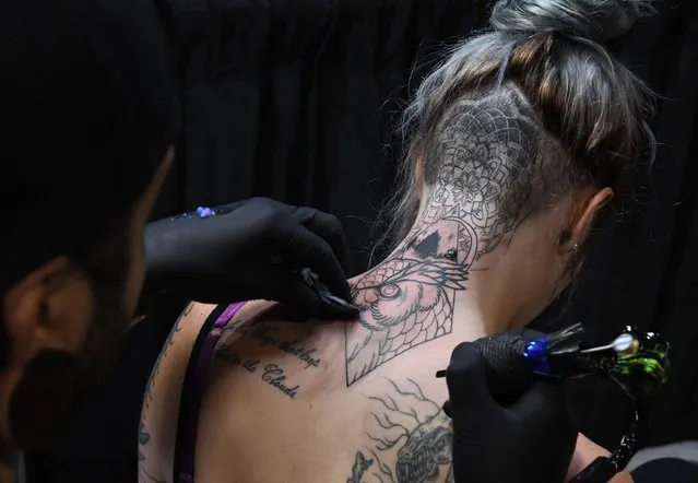 Tattoo artist Trip works on a tattoo for Melissa Chester at the LA Tattoo Convention in Long Beach, California, on August 19, 2017. (Photo by Mark Ralston/AFP Photo)