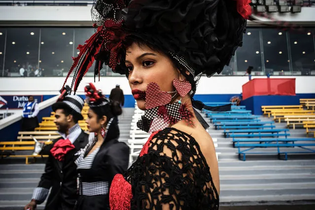 Members of the public and models showcase outfits from local South African designers during the pre race fashion show on the Greyville Race Course in Durban on July 2, 2016. The Durban July horse race is the biggest horse racing event on the African continent and a high social event where South African celebrities dress up and watch the race. It attracts close to 100,000 spectators and bets are placed in excess of 30 million US dollars. (Photo by Marco Longari/AFP Photo)