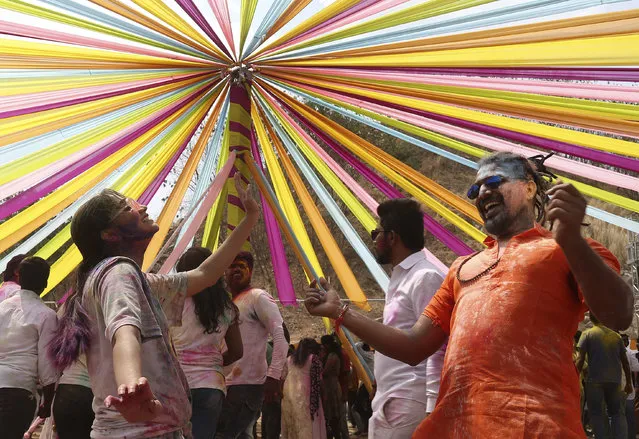 Indians dance and throw colored powder during Holi festival celebrations in Hyderabad, India, Tuesday, March 10, 2020. The festival heralds the arrival of spring. (Photo by Mahesh Kumar A./AP Photo)